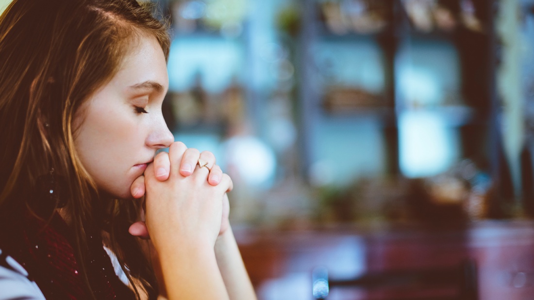 Frau betet in Kirche