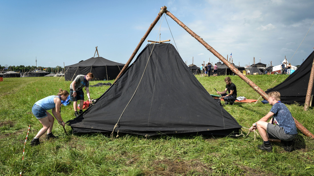 Teilnehmer bauen im VCP-Camp ein Zelt auf