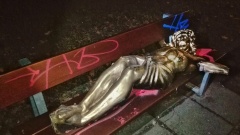 Goldfarbene Jesus-Skulptur auf Parkbank