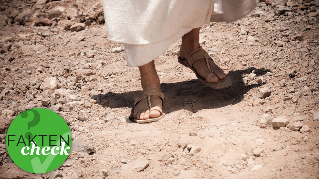 Person mit Sandalen auf staubigem Boden