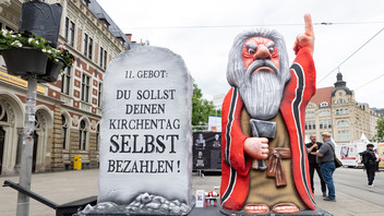 Kritische Installation mit Moses-Figur und Gesetztestafel mit 11. Gebot "Du sollst deinen Kirchentag selbst bezahlen!"auf dem Katholikentag in Erfurt.