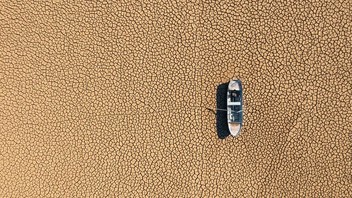 Ein Boot liegt auf ausgetrockneter Erde.