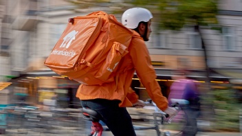 verschwommener Fahrradkurier im Dienst in Berlin