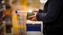 Eine Person öffnet im Supermarkt einen Geldbeutel
