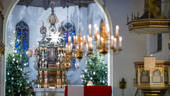 Mit Sternen und Lichtern weihnachtloich geschmückter Kirchenraum