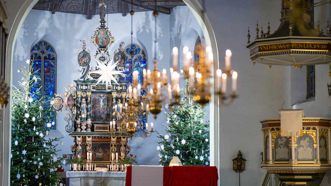 Mit Sternen und Lichtern weihnachtloich geschmückter Kirchenraum