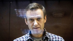Portrait von Alexej Nawalny, der hinter einer Scheibe vor Gericht steht.