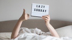 Person, nicht sichtbar, liegt mit einem "Lazy Sunday" - Spruch im Bett