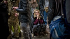Eine Frau sitzt in Tränen am Bahnhof, um Kiew zu verlassen.