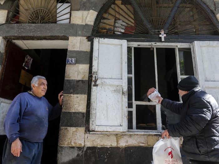 Ein Mann kauft christliches Sakramentsbrot in der Bäckerei der Gebrüder Salamouny im Viertel Hanania in der syrischen Altstadt von Damaskus am 18. Januar 2024