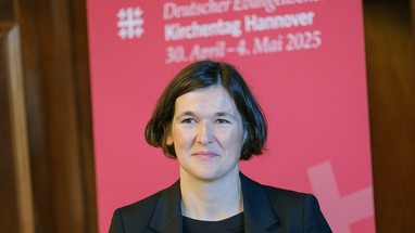 Kristin Jahn, Kirchentags-Generalsekretärin, vor dem Kirchentagsbanner für Hannover 2025