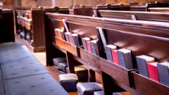 Kirchenbänke mit Kissen und Gesangbüchern