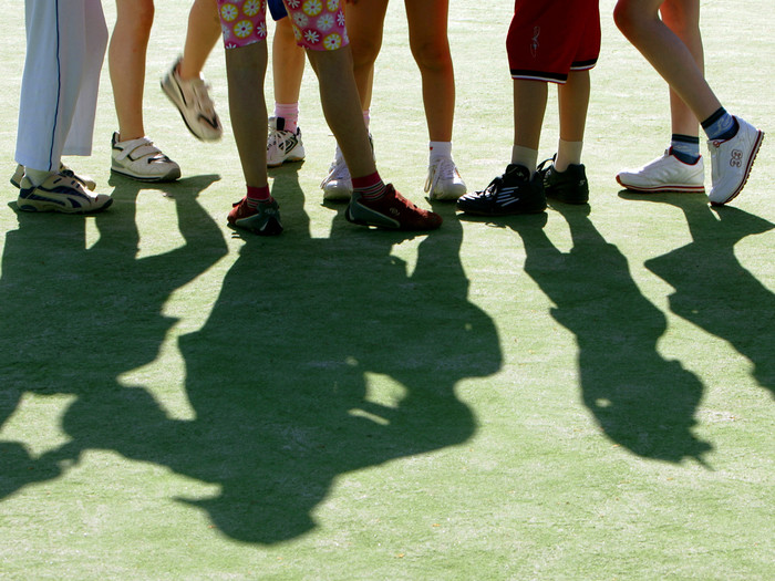 Schüler beim Schulsport - Bundesjugendspiele. Es sind nur die Beine und die Schatten der Kinder zu sehen