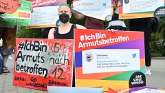 Protestierende halten Transparente mit dem Hashtag #IchBinArmutsbetroffen bei einer Demonstration in Berlin