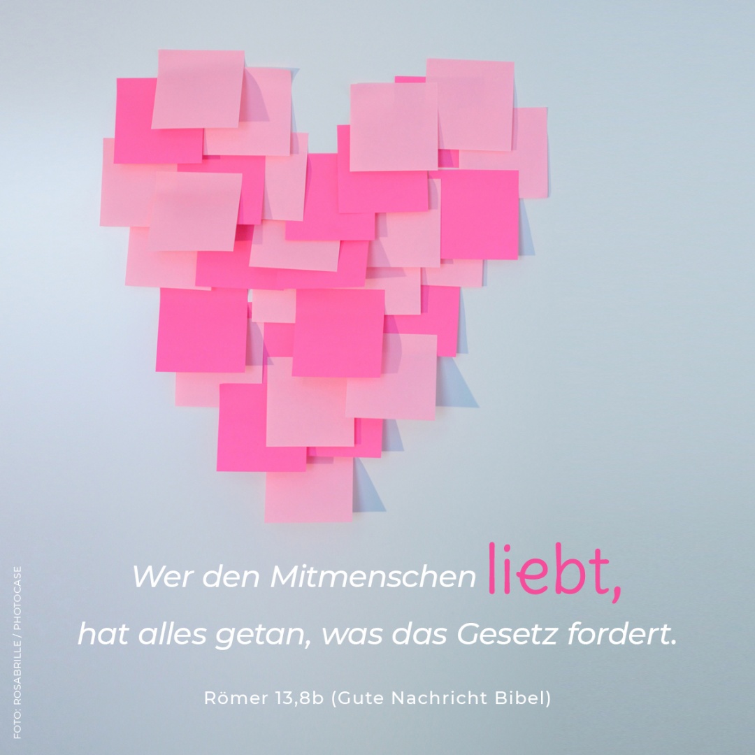 Herz aus pinken Post-its an hellgrauer Hand