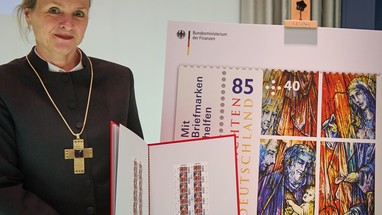 Prälatin Anne Gidion, Bevollmächtigte des Rates der Evangelischen Kirche in Deutschland, präsentiert die Sonderbriefmarke