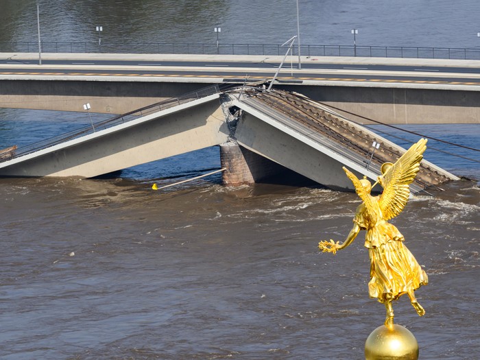 Die Hochwasser führende Elbe fließt an der zum Teil eingestürzten Carolabrücke entlang. Im Vordergrund ist der Engel "Fama" auf der Kunstakademie zu sehen