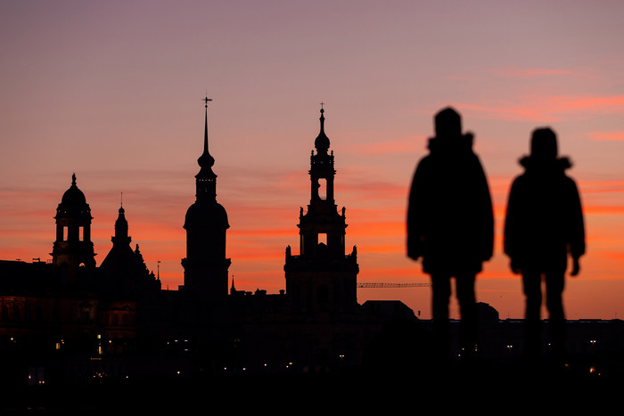 Zwei Kinder schauen auf die Silhouette der Altstadt von Dresden mit Hofkirche und Dresdner Schloss