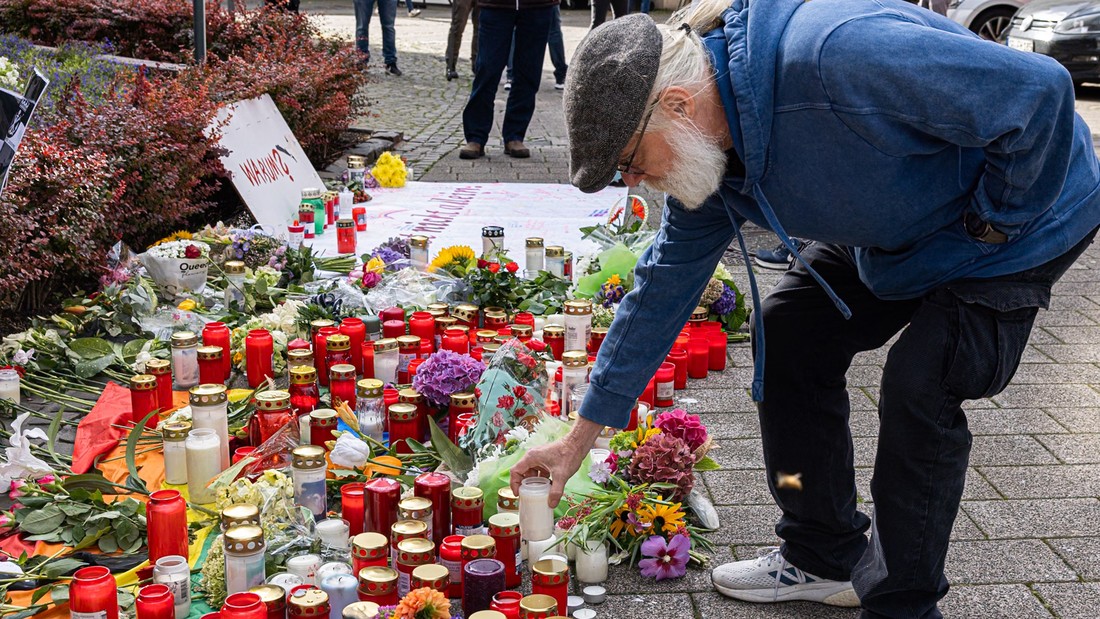 Menschen legen zum Gedenken an die Opfer Blumen nieder