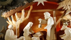 Aus hellem Holz geschnitzte Krippenfiguren von Maria und Josef, dem Jesuskind in der Krippe, Schafen und Hirte.