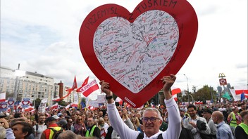 Menschen nehmen am 1. Oktober 2023 in Warschau am "Marsch der Millionen Herzen" der Opposition teil. Ein Mann hält ein großes rotes Herz mit vielen Unterschriften pro Donald Tusk in die Luft