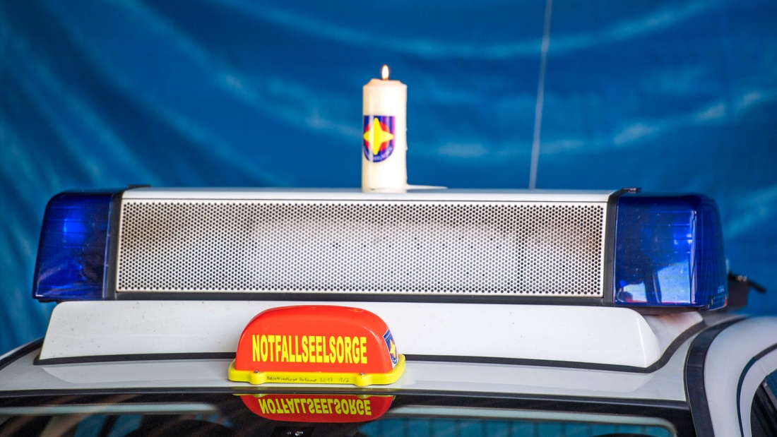 Kerze mit dem Logo der Notfallseelsorge auf einem Einsatzfahrzeug