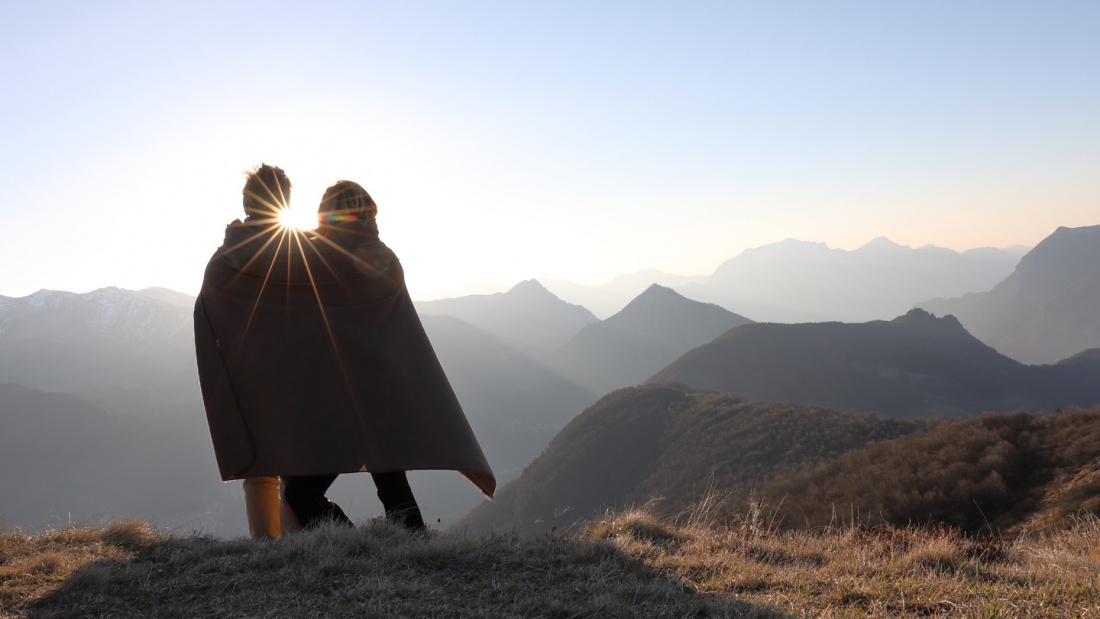 Zwei Personen unter einer Decke auf dem Berggipfel