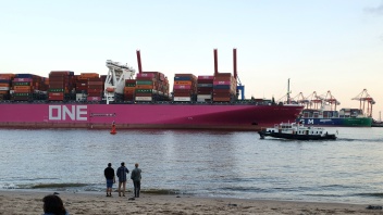 Beladenes Containerschiff fährt auf der Elbe Richtung Nordsee.