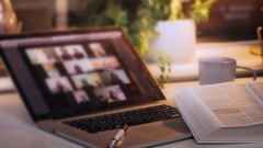 Laptop mit Videokonferenz auf einem Schreibtisch mit Bibel