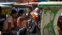 Eine Frau trinkt in Indien aus einer Flasche