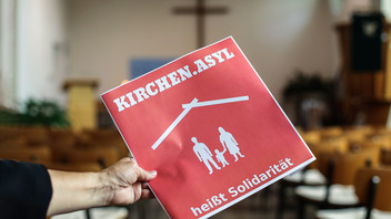 Schild mit der Aufschrift "Kirchenasyl heisst Solidarität" in einer evangelischen Kirche