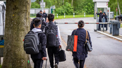 Flüchtlinge mit Gepäck am Eingang zur LAB Bramsche, dem Ankunftszentrum der Landesausnahmebehörde Bramsche-Hesepe in Niedersachen bei Osnabrueck.