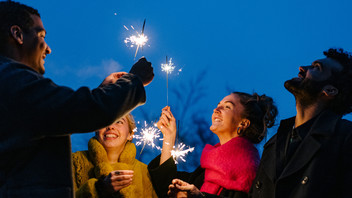 Menschen stehen im Kreis und halten Wunderkerzen in den Händen