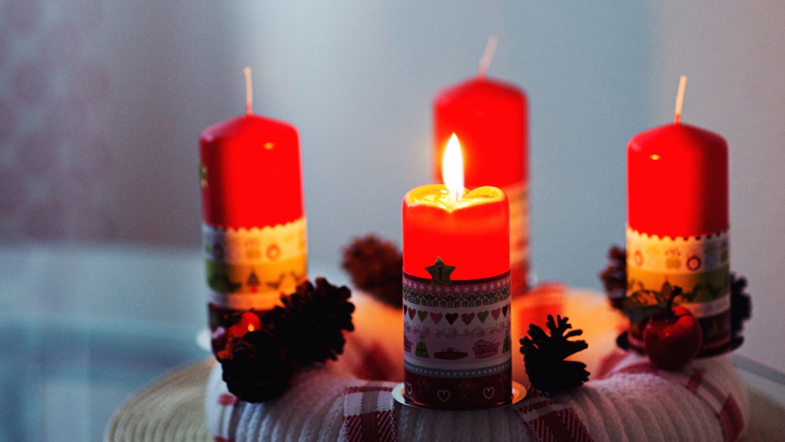 Adventskranz und einer brennenden Kerze.