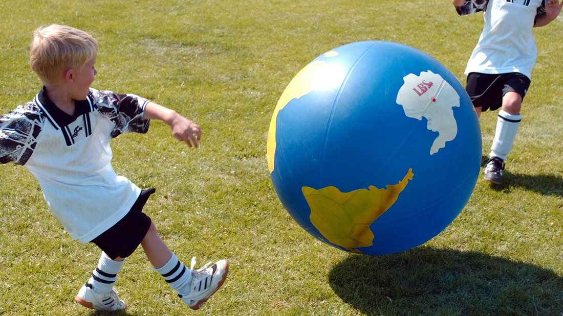 Kinder spielen mit großem Ball