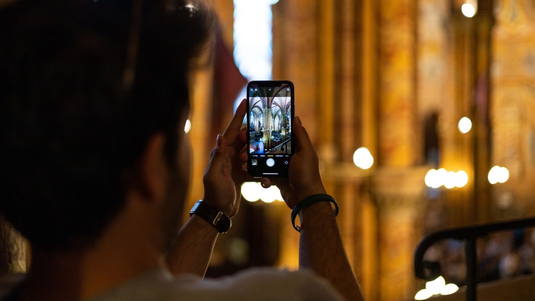 Person filmt mit dem Handy in der Kirche