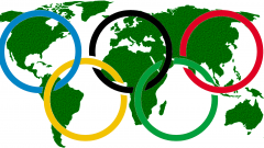 Olympische Ringe vor einer Weltkarte