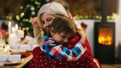 Oma umarmt Enkel an Weihnachten