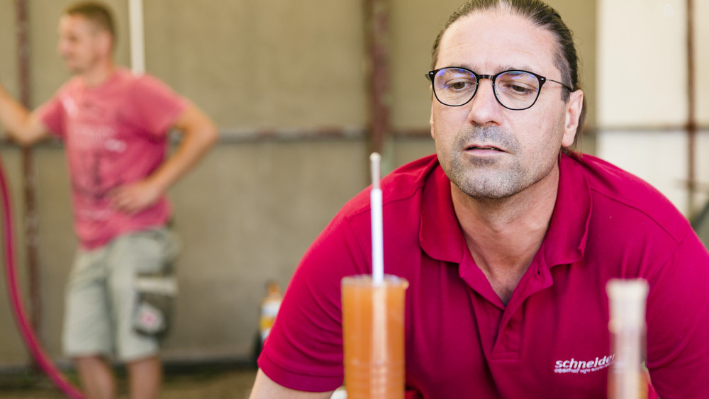 Mann mit Testgerät für Zuckergehalt des Safts