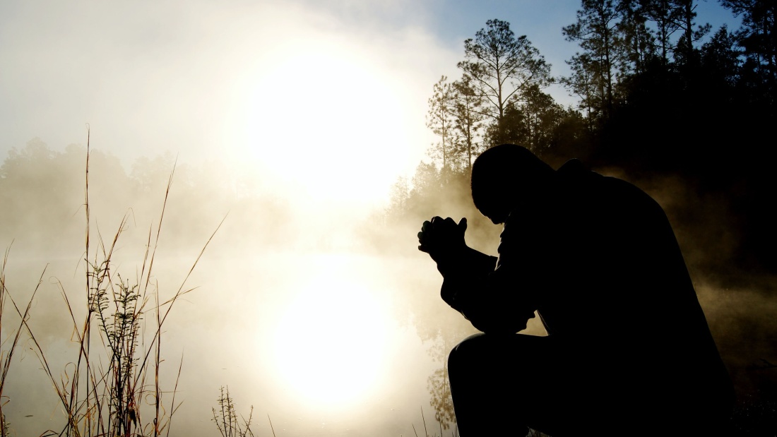 Ein Mann in einer nebenumhüllten Landschauft und betet