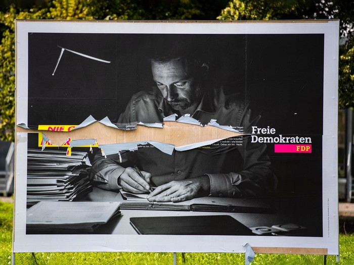 Ein zerrissenes Wahlkampfplakat der FDP mit dem FDP-Vorsitzenden Christian Lindner säumt einen Kreisverkehr in Berlin am 24. August 2021 vor der Bundestagswahl in Deutschland am 26. September.