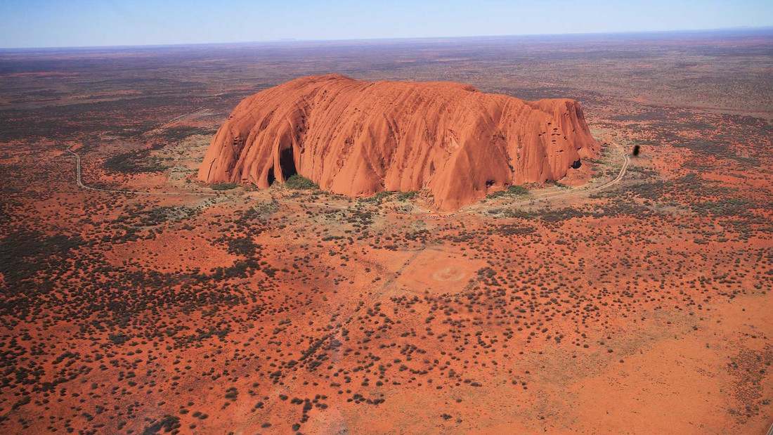 Der rote, freistehende Felsen Uluru aus der Luft aufgenommen.