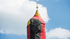 In deutschlandfarben verkleideter Kirchturm im oberbayerischen Kirchseeon in St. Coloman