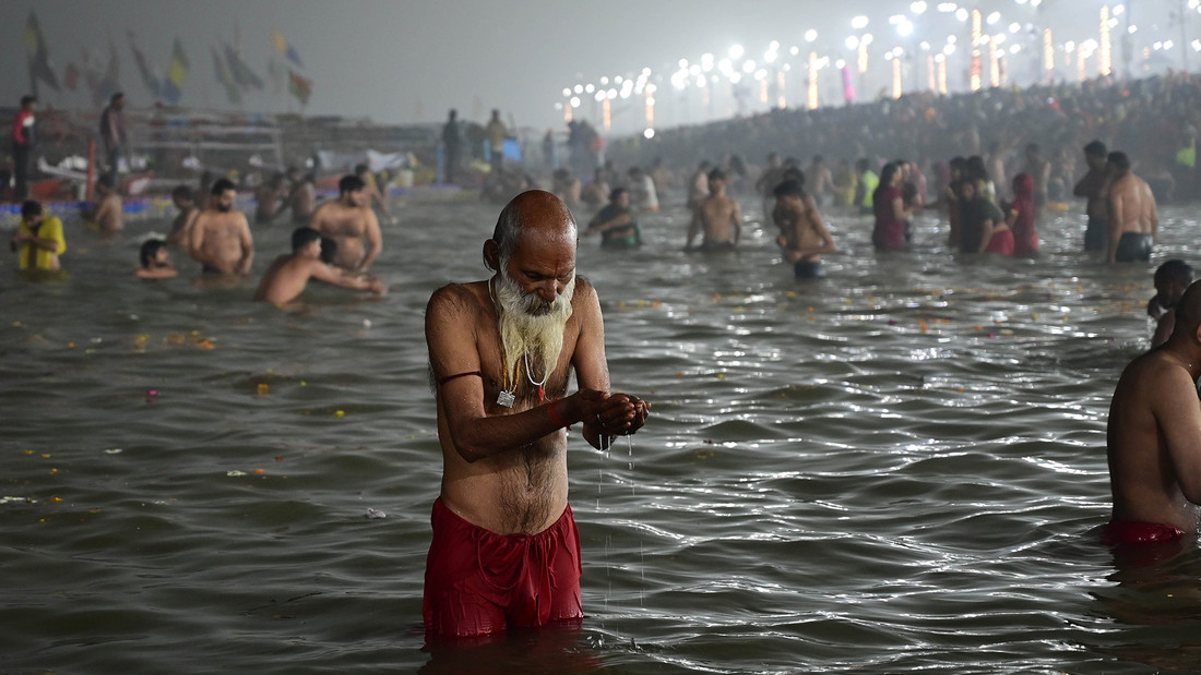 Gläubige versammeln sich am Fluß Sangam in Indien, Prayagraj, um am ersten Tag der Maha Kumbh Mela ein heiliges Bad zu nehmen.