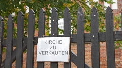 Tor zum Kirchhof mit Verkaufs Schild für Kirche