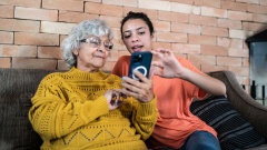Seniorin und junge Frau am Smartphone
