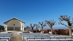 Offene Kapelle bei blauem Himmel mit weißen Bänken