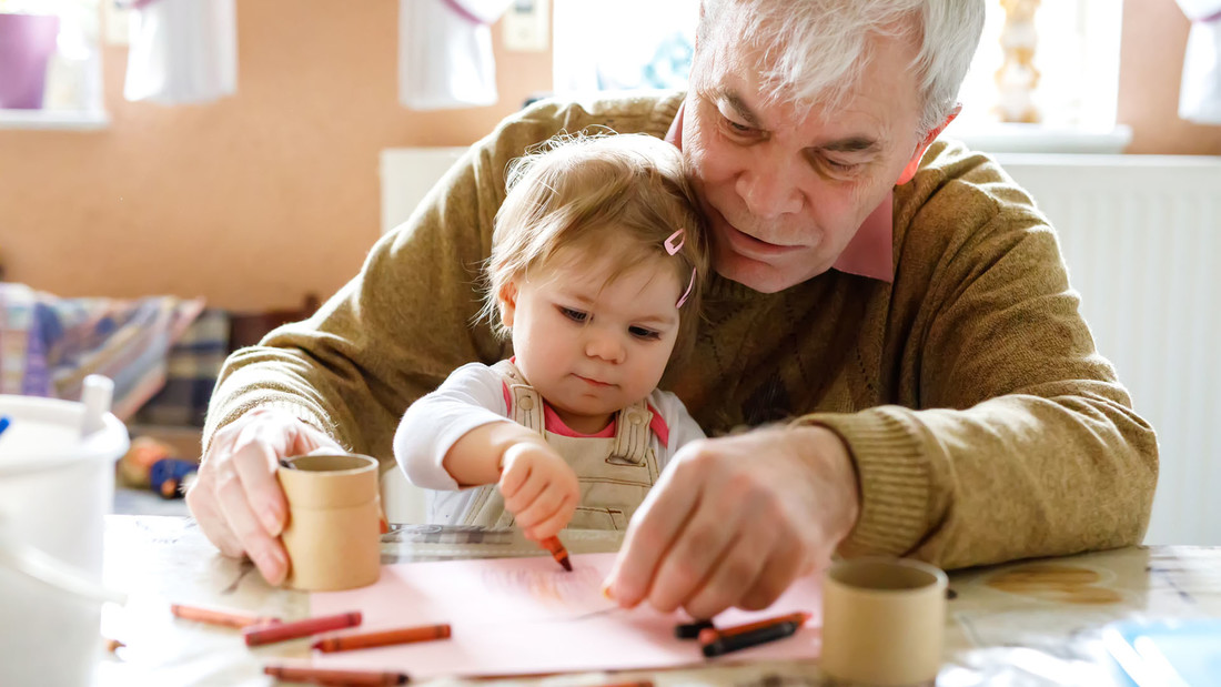 Senior und Kleinkind malen gemeinsam