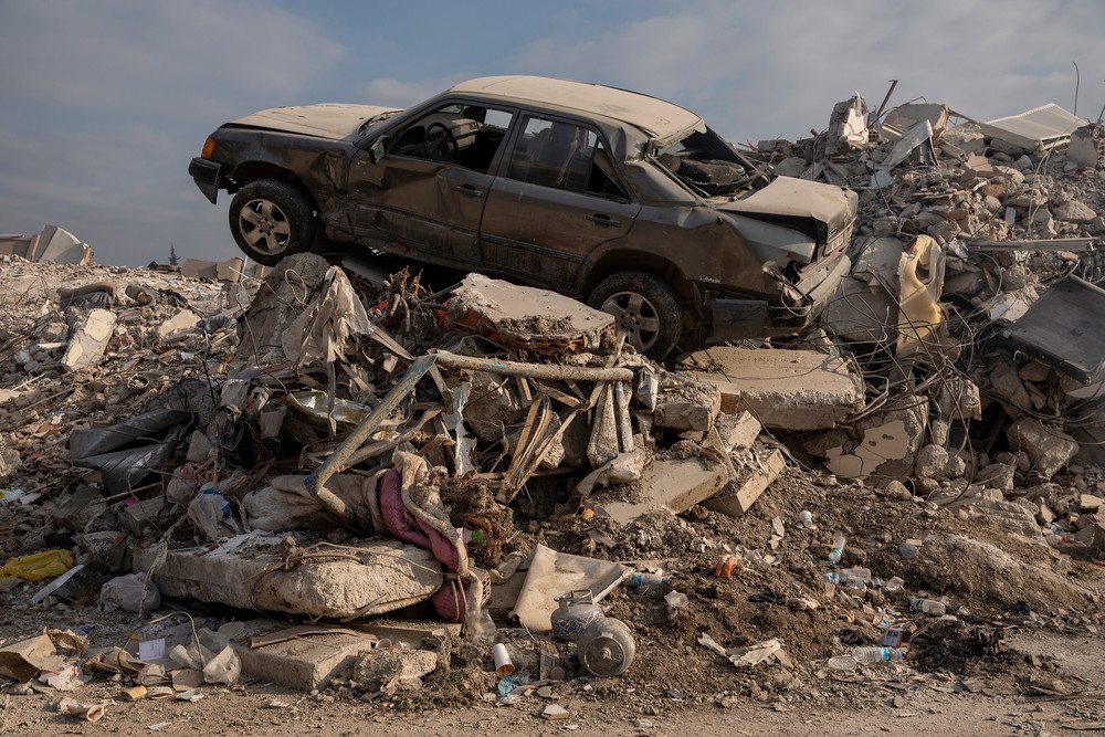 Schutthaufen in Hatay am 12. Februar 2023 im Stadtzentrum mit einem verbeulten Auto auf dem Schuttberg