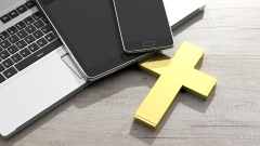 Laptop mit Smartphones und Kreuz